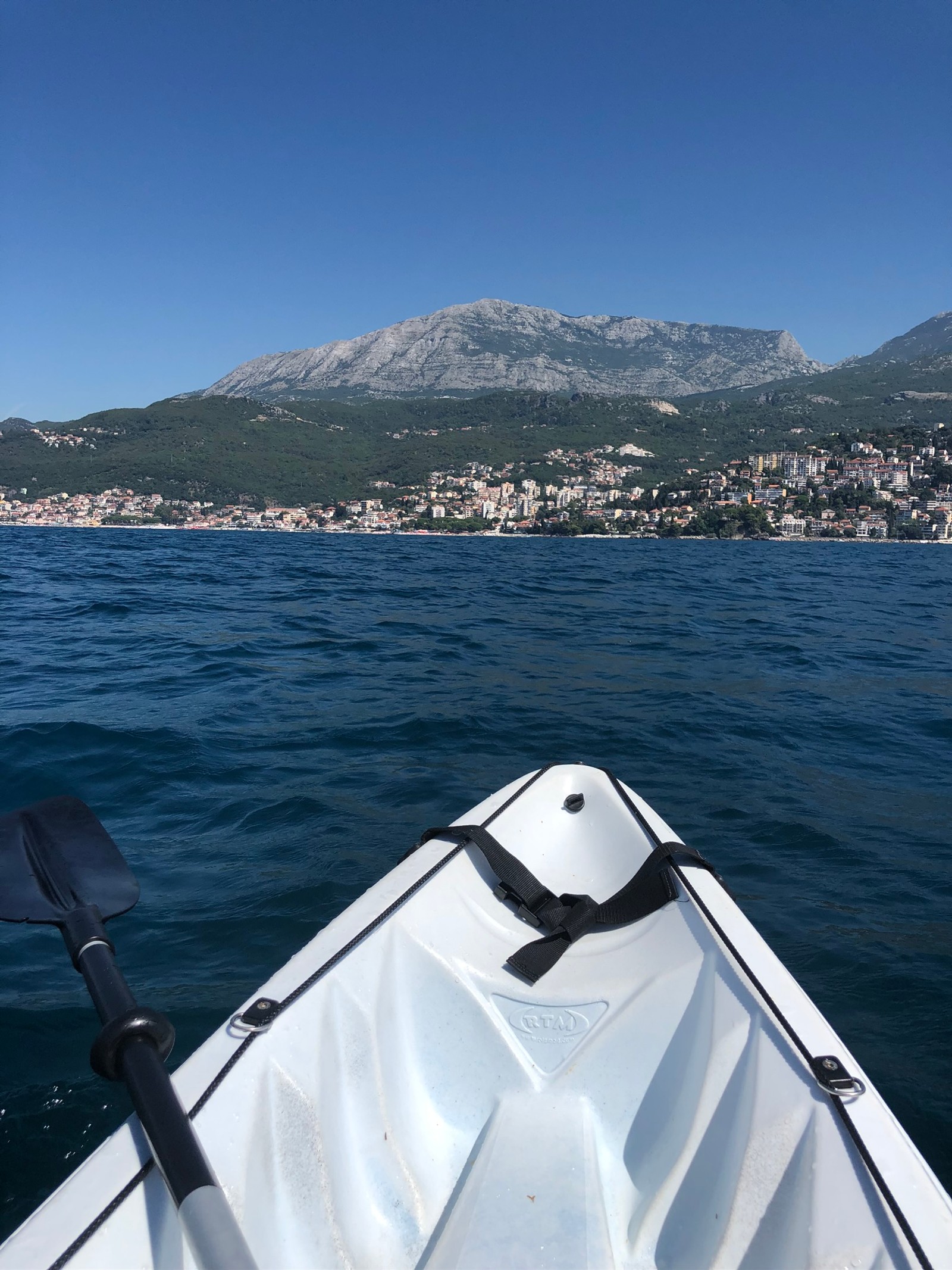 Há um barco que navega pela água com montanhas ao fundo (mar, barco, fiorde, água, iate)