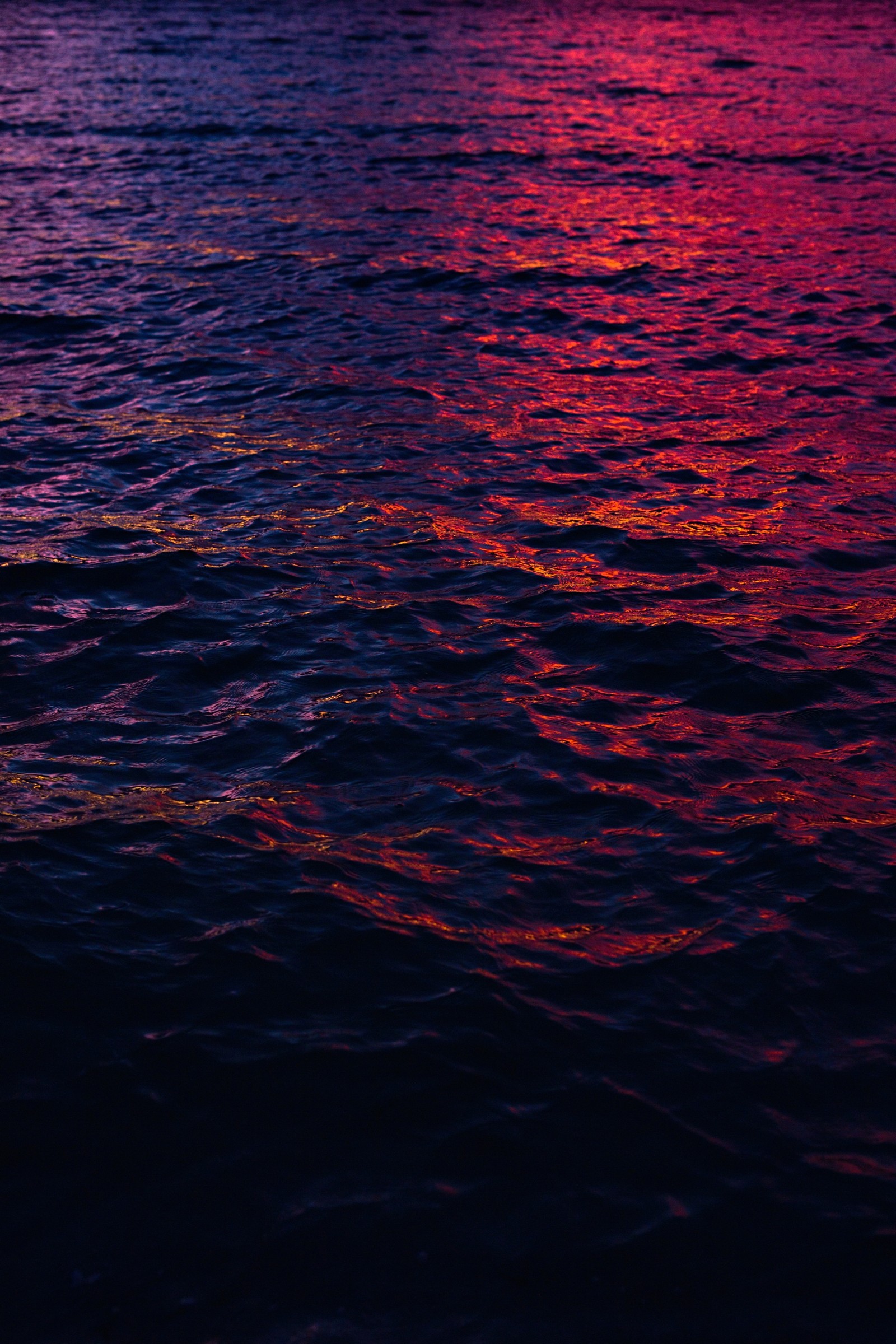 Purple and red sunset over the ocean with a boat in the distance (blue, water, red, sea, horizon)