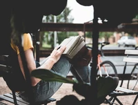 Author engrossed in writing a diary while sitting outdoors during vacation.