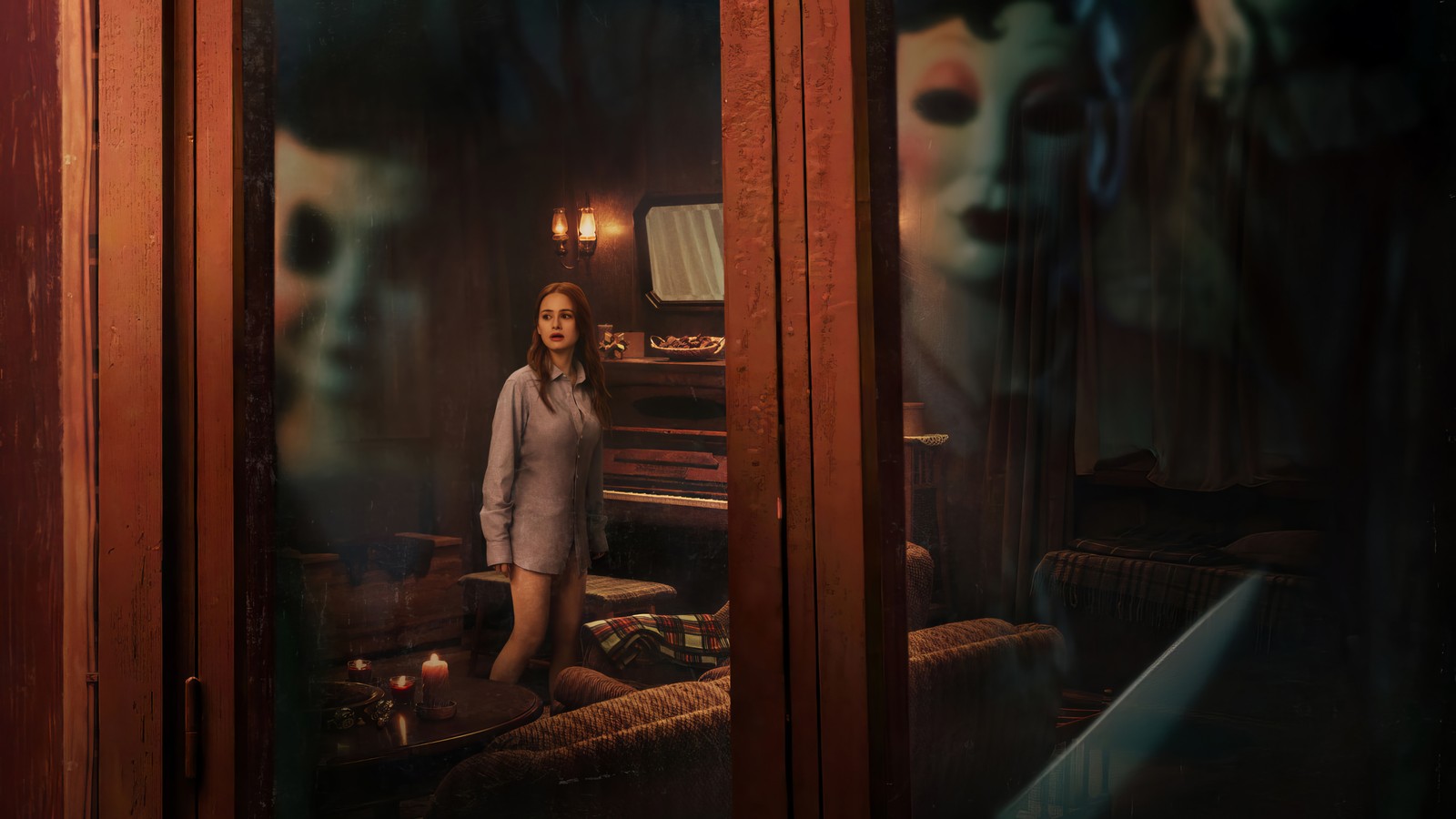 Una mujer está de pie en una habitación con un espejo y un hombre la mira (los extraños capítulo 1, the strangers chapter 1, película, madelaine petsch, cartel)