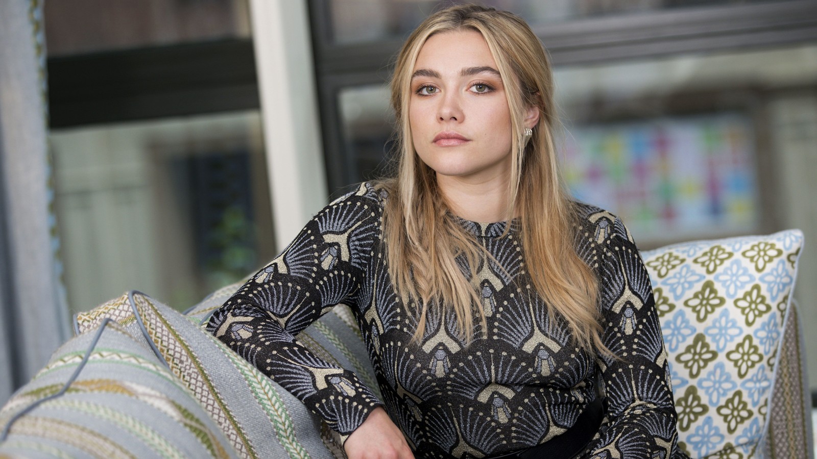 Femme araffée assise sur un canapé avec un coussin devant elle (florence pugh, anglais, actrice, célébrité, femmes)