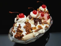 Delicioso sundae com três sabores, chantilly, nozes e cerejas