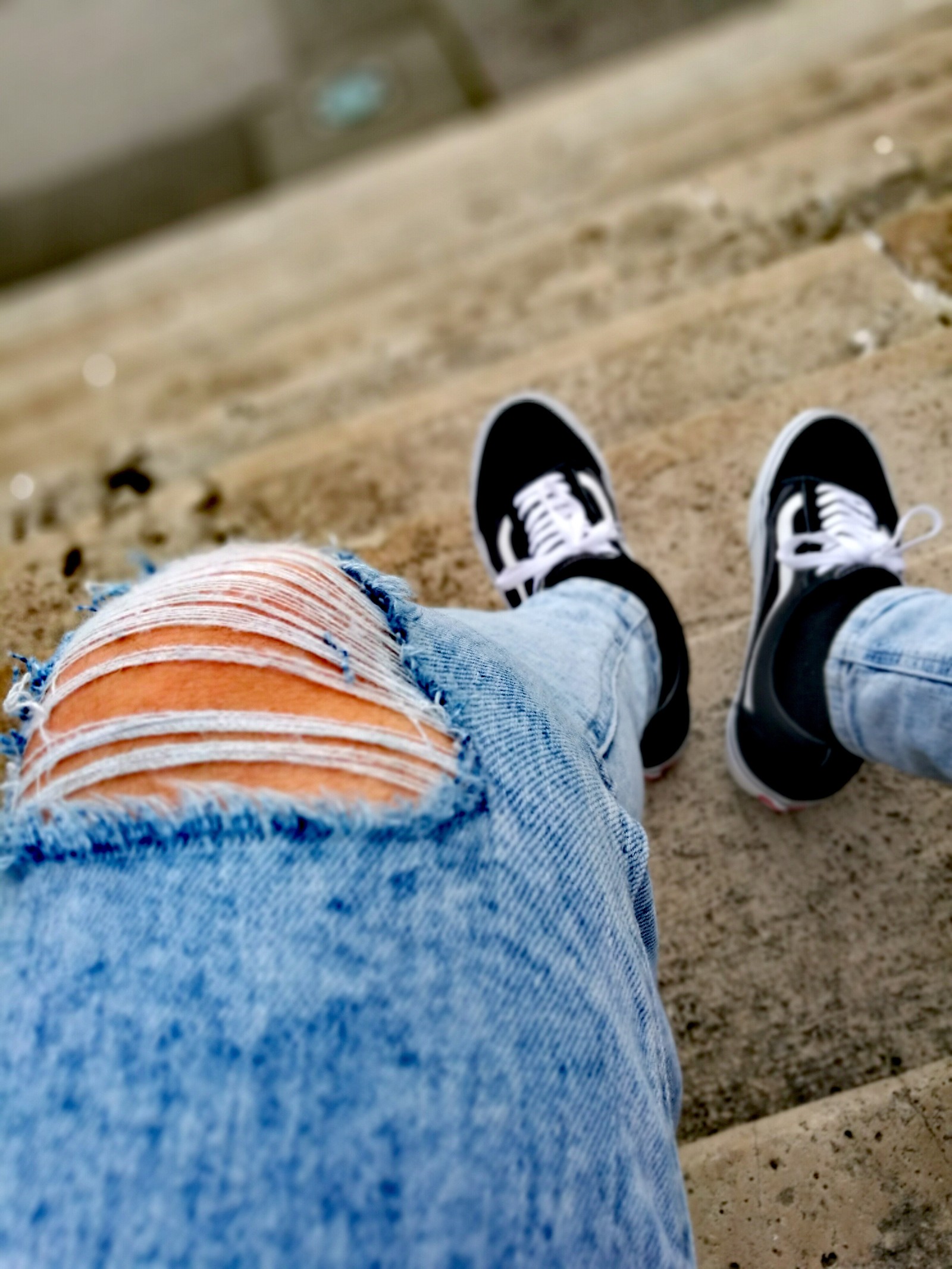 Quelqu'un est assis sur les marches avec les pieds en l'air (vans, vans oldschool)