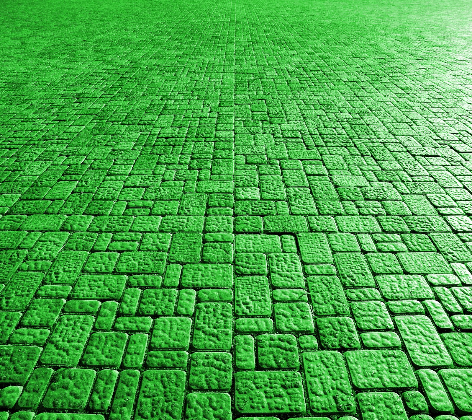 A close up of a green brick floor with a green umbrella (green, path, stone, texture)