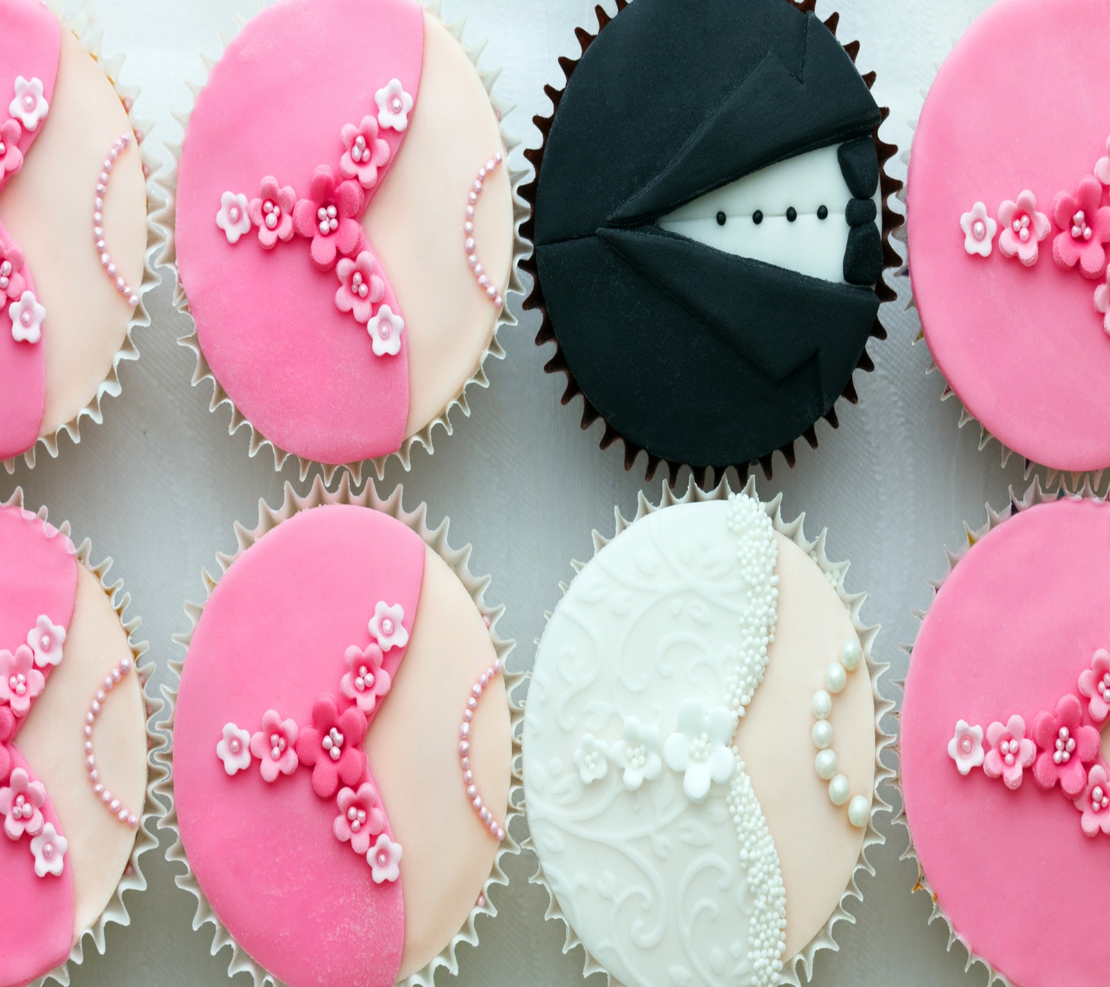 Hay muchos cupcakes con glaseado rosa y glaseado blanco (pastelito, boda)