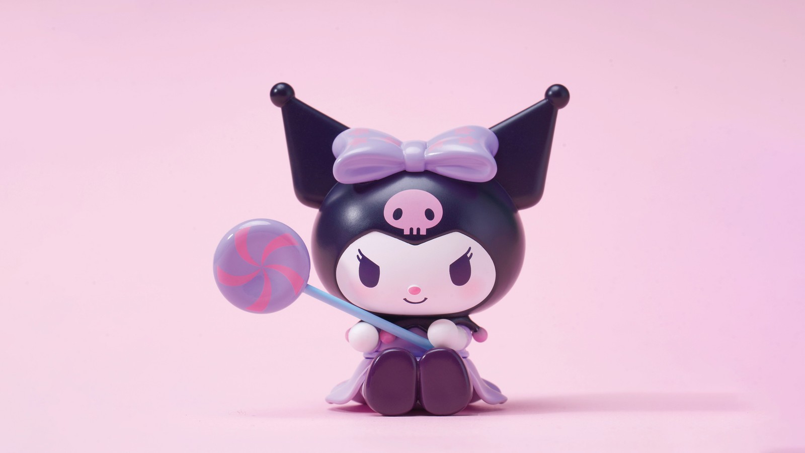 Há um pequeno brinquedo com um laço nele (kuromi, desenho animado fofo, doces, rosa pastel, estética rosa)