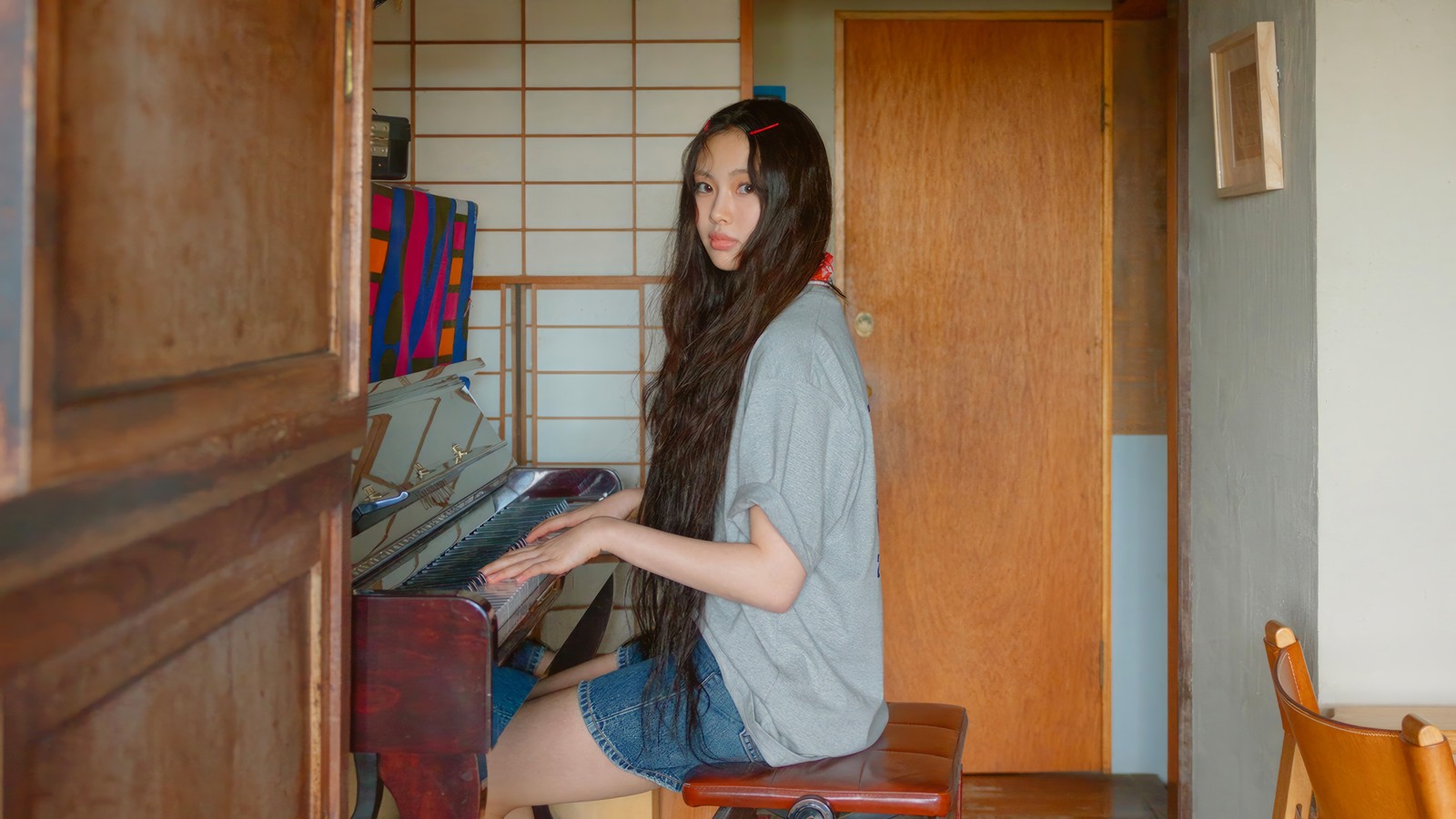 Arafed woman sitting at a piano in a room (newjeans, kpop, new jeans, korean girl group, k pop)