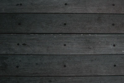 Piso de tablones de madera oscura manchada con grano de madera visible y sujetadores