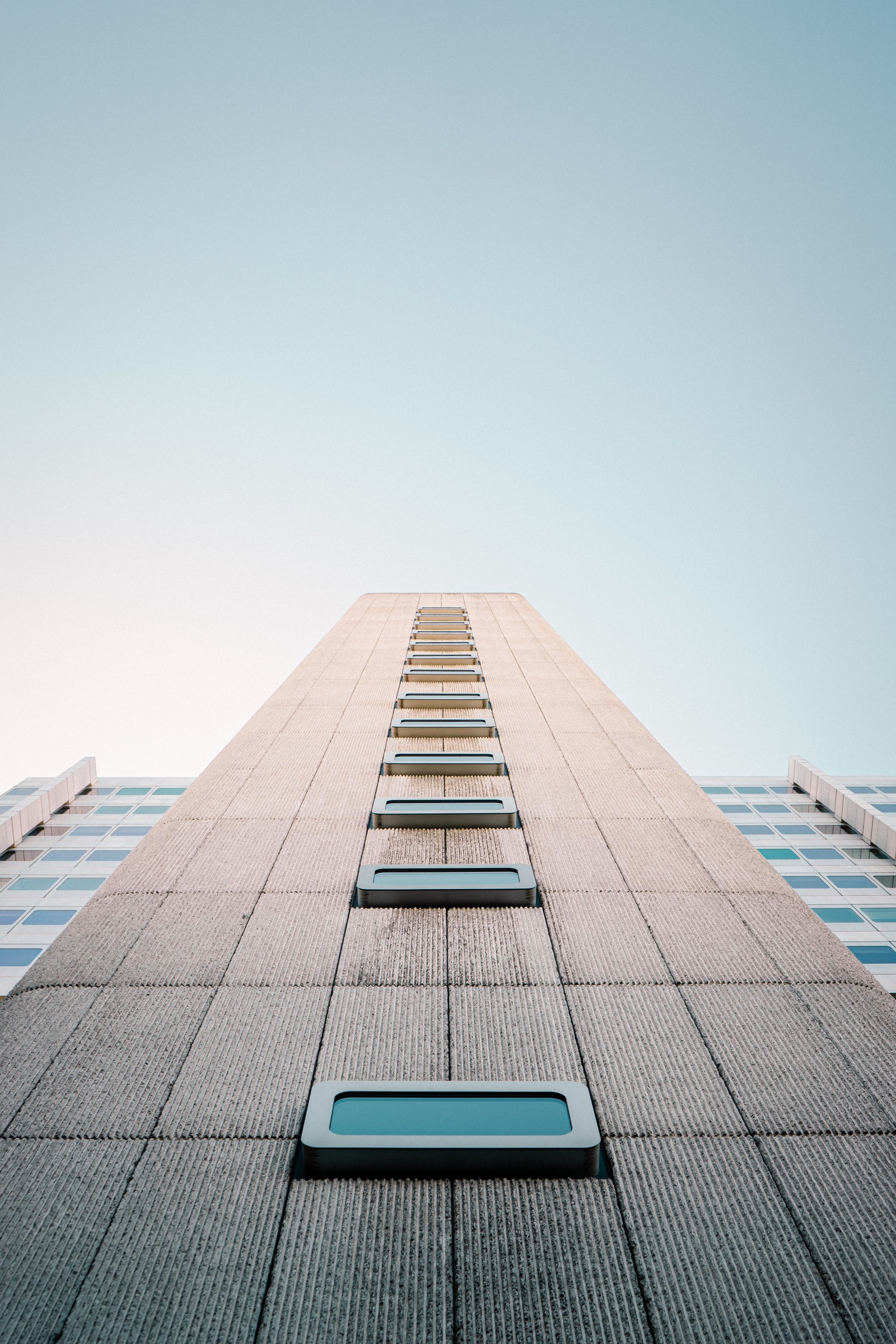 Une vue d'un bâtiment haut avec un ciel en arrière-plan (architecture, bâtiment, bleu, journée, ligne)