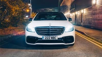 Sleek Mercedes-Benz S63 AMG parked under streetlights, showcasing its distinctive grille and sporty design.