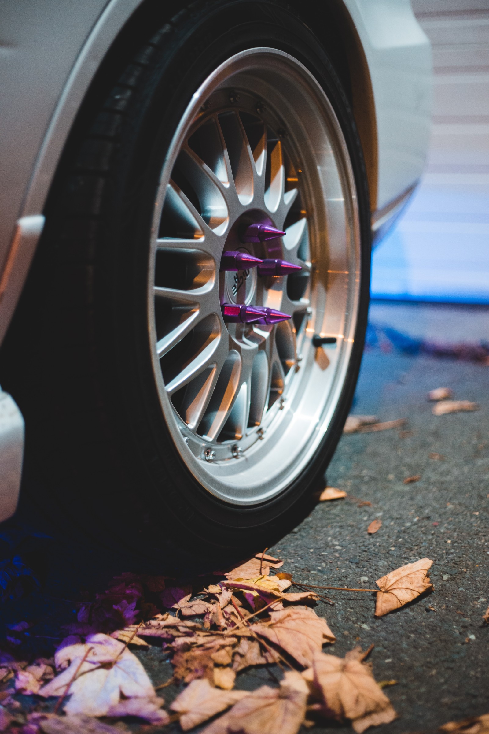 A close up of a car tire with a purple shock absorbing device (tire, alloy wheel, rim, wheel, automotive tire)