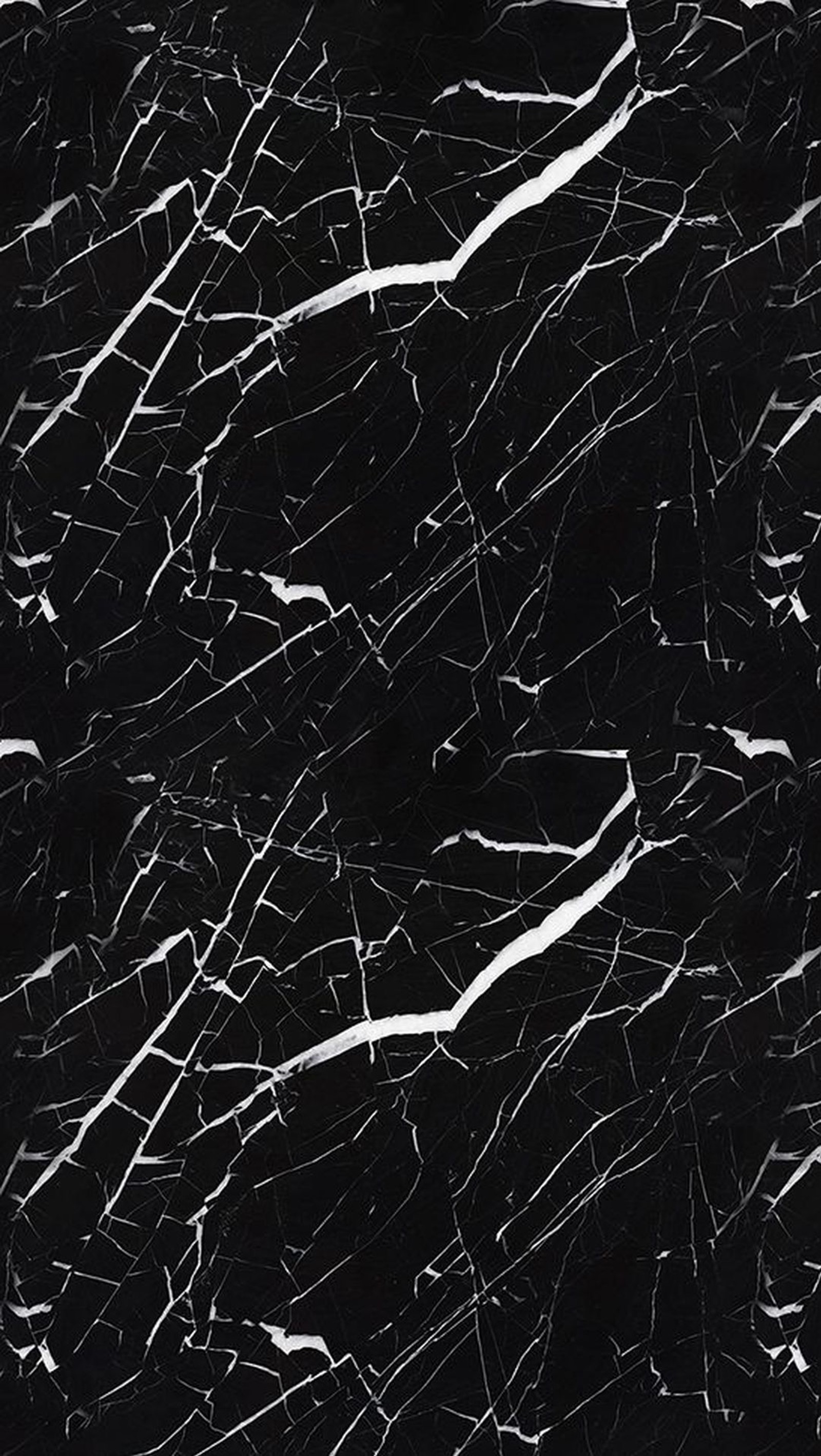 A close up of a black and white marble surface with a black background (cracked, paint)