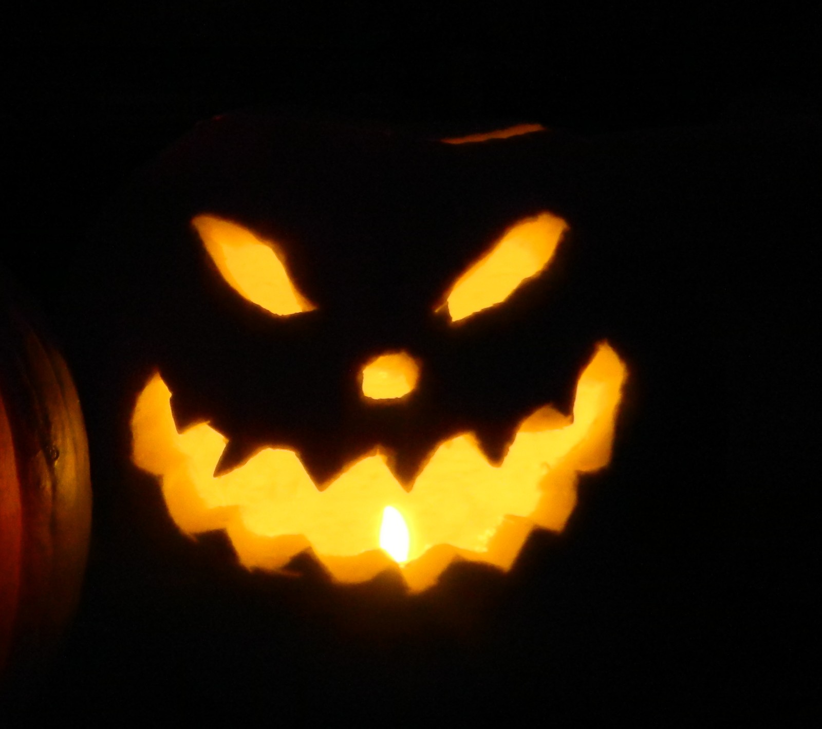 Gros plan d'une citrouille illuminée avec un visage effrayant (halloween, jean riget)