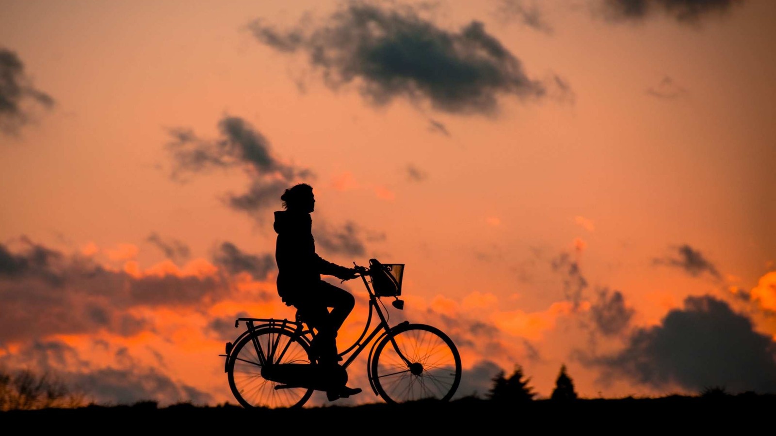 Arafed image of a person riding a bike at sunset (silhouette, sunset, cloud, bicycle, orange)