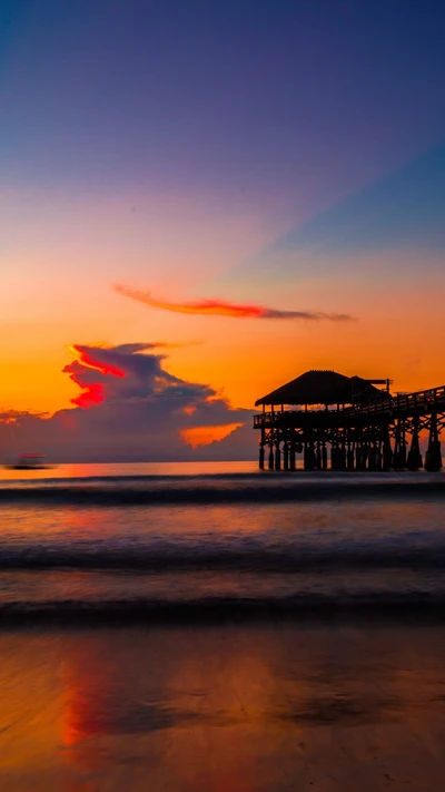 Bernstein Sonnenuntergang über Pier und ruhigem Meer