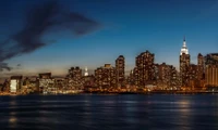 Nighttime Skyline of New York City with Reflections and Urban Landmarks