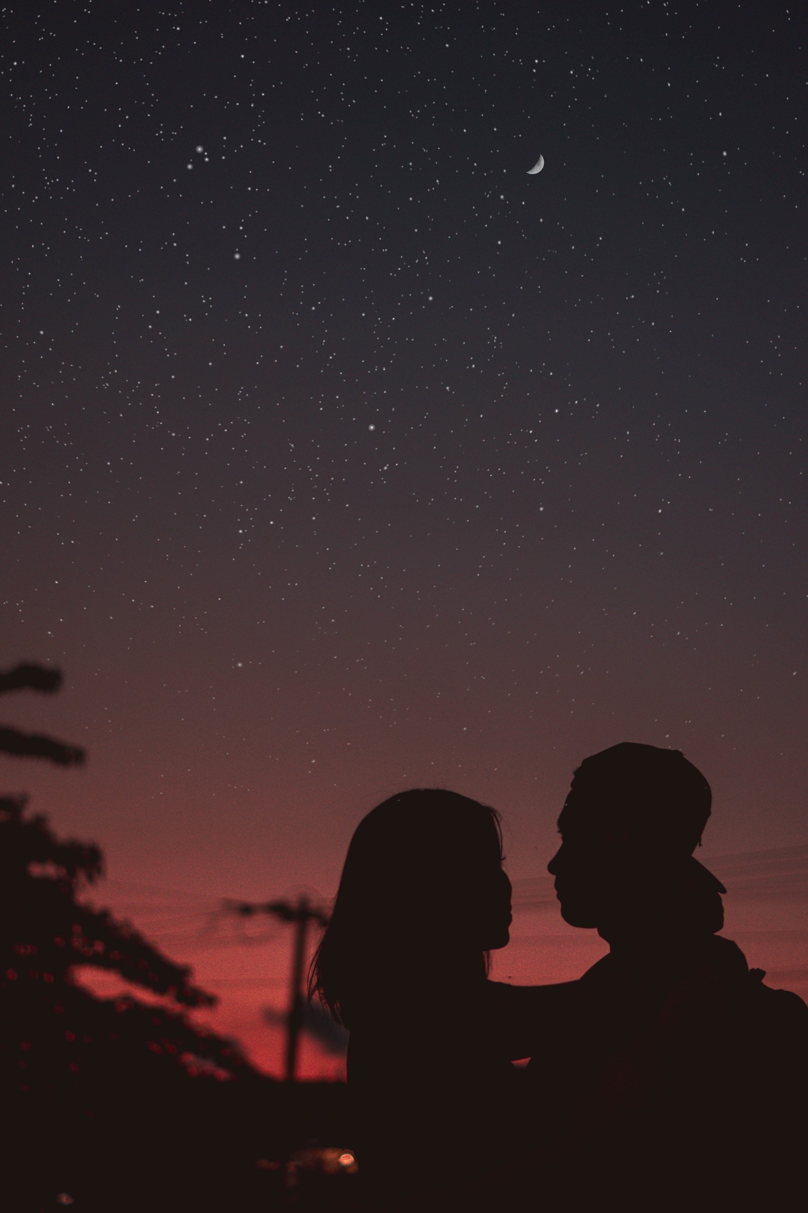 Casal árabe em pé na frente de um céu noturno com a lua ao fundo (preto, noite, estrela, atmosfera, nuvem)