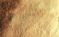 Textured earthy surface with shades of gold and brown resembling soil or natural materials.