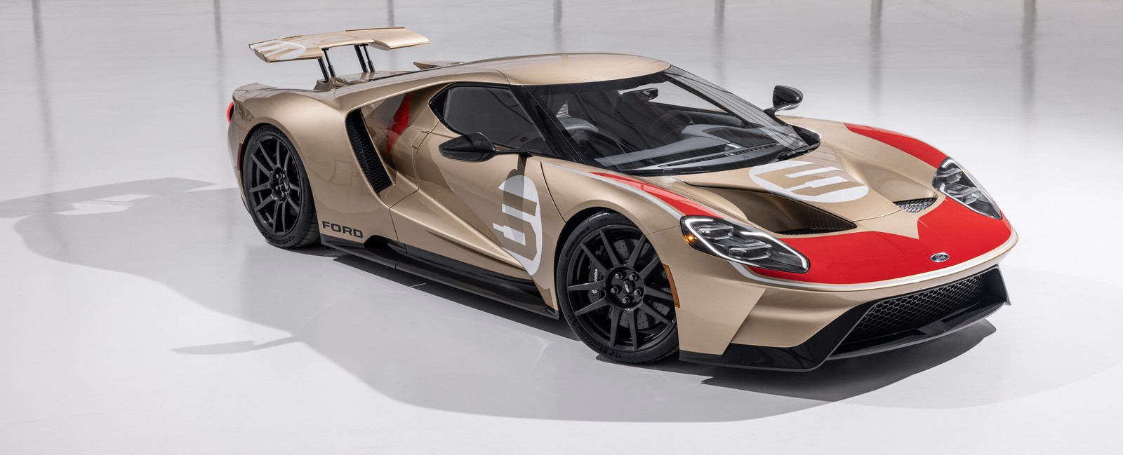 Un primer plano de un coche sobre una superficie blanca con una franja roja (ford gt, edición de herencia, supercoches, edición especial, 2022)