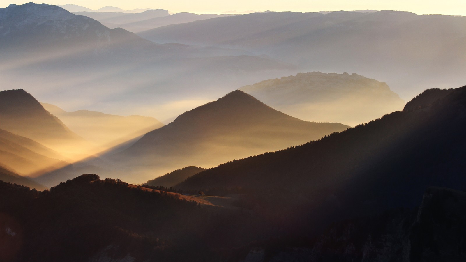 Montagnes avec un rayon de soleil au milieu et une vallée en dessous (brumeux, montagnes, lever de soleil, vallée, nature)