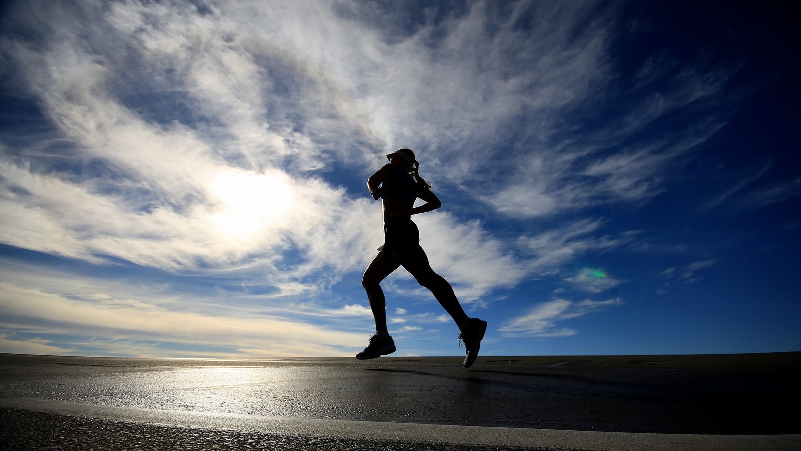 Um homem correndo em uma estrada sob um céu nublado (correndo, maratona, água, azul, nuvem)