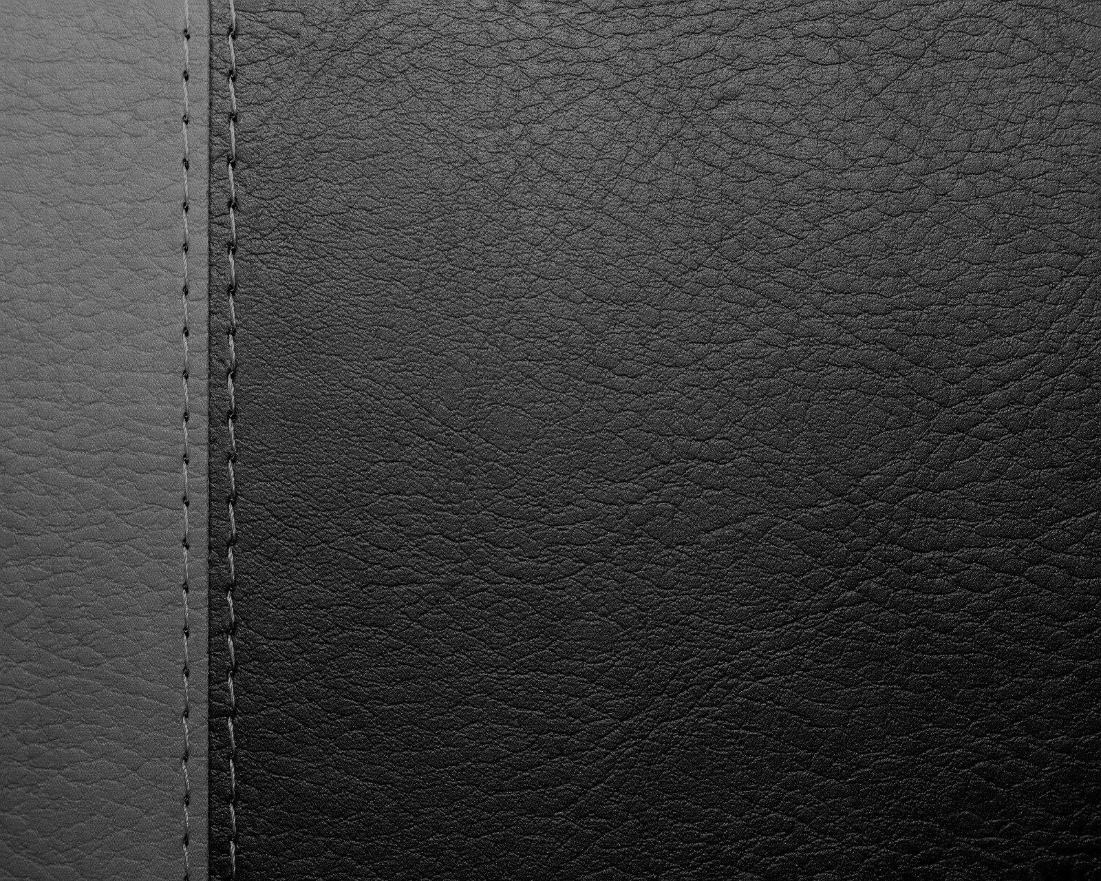 A close up of a black leather texture with a stitching edge (abstract, backgound, black grey leather)