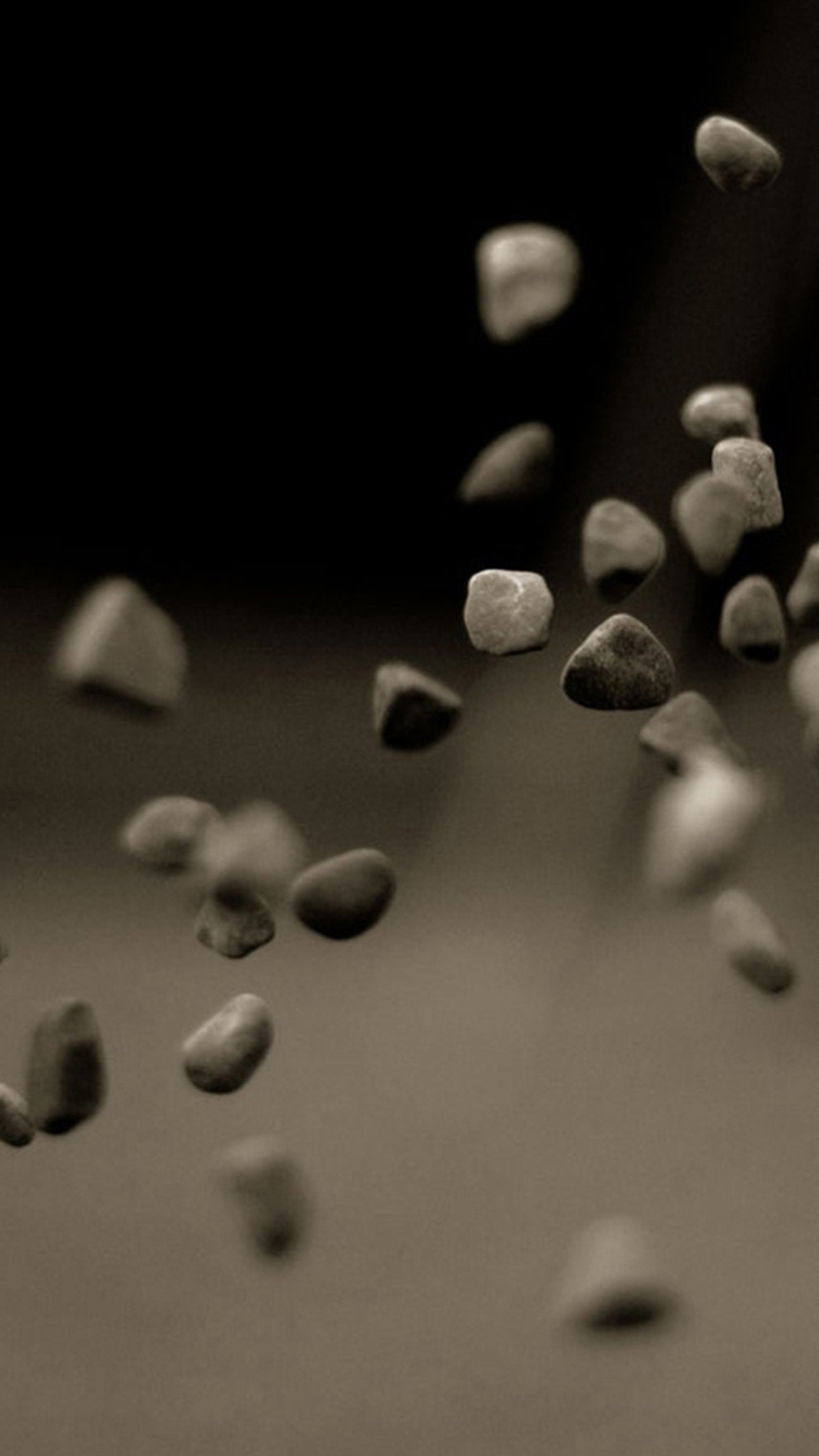 Araffes of pebbles are falling from a black and white photo (3d, stone, wall, wallpapers)