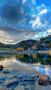 Reflexões de outono: lago sereno cercado por montanhas majestosas e um céu dramático