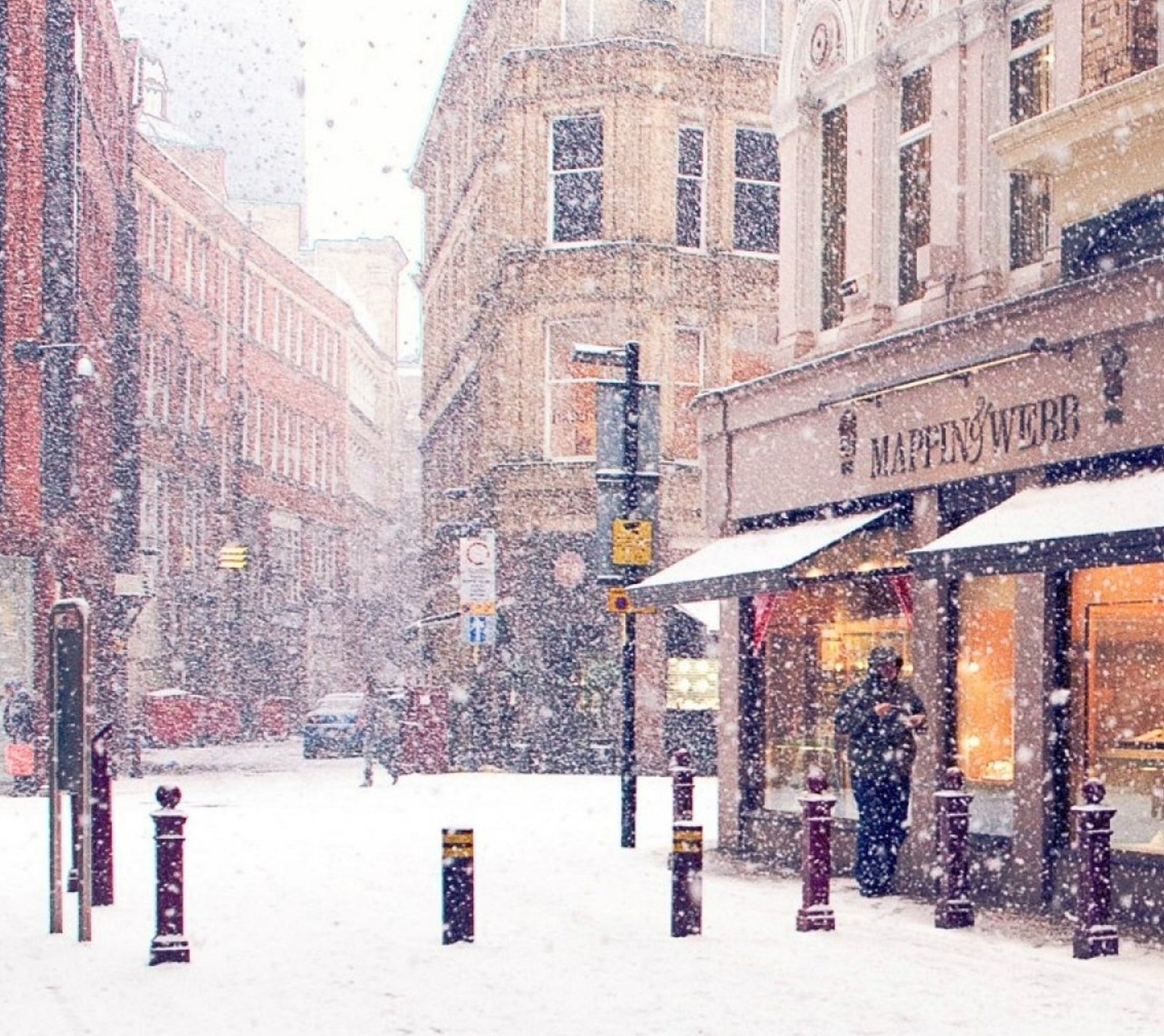 Une journée enneigée dans une ville avec une vitrine et une personne marchant dans la rue (ville, jour, enneigé, hiver)