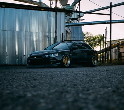 Mitsubishi Lancer modifié dans un cadre industriel rugueux.