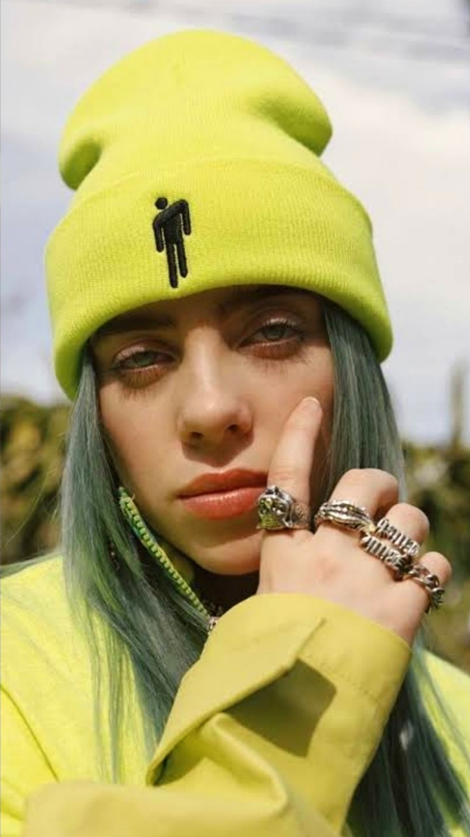 Un primer plano de una persona con cabello verde usando un sombrero amarillo (billie eilish, billie elish, billieeilish, famoso, niña)