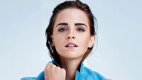 Emma Watson dans une tenue bleue frappante, mettant en valeur sa beauté naturelle et sa confiance lors d'une séance photo captivante.