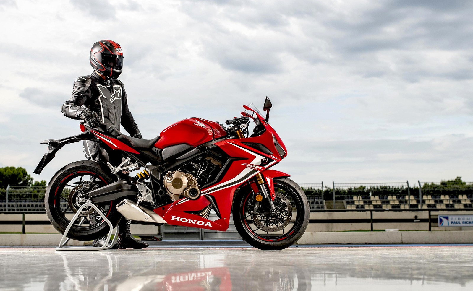 Ein arabischer mann in einer lederjacke und einem helm steht neben einem roten motorrad (honda cbr650r, biker, rennfahrer, fahrräder, 4k hintergrund)