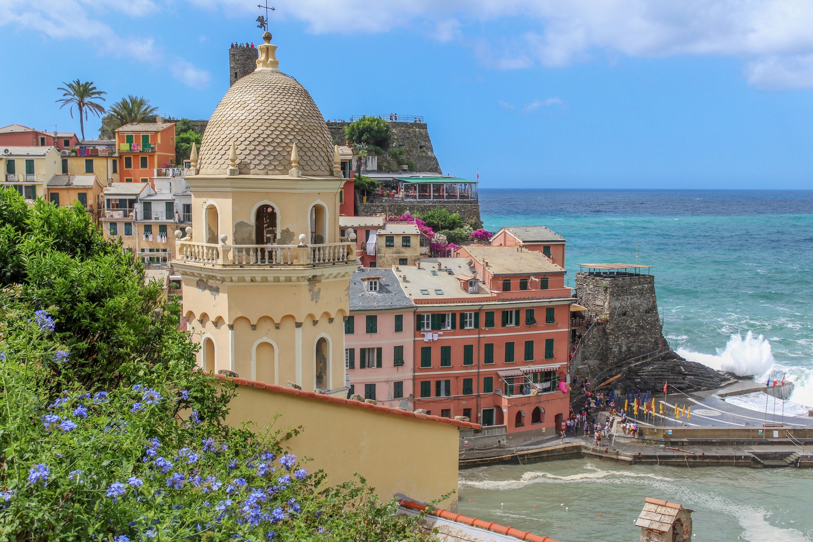 Vista aérea de una playa con un edificio y un océano azul (vernazza, atracción turística, ciudad, turismo, edificio)