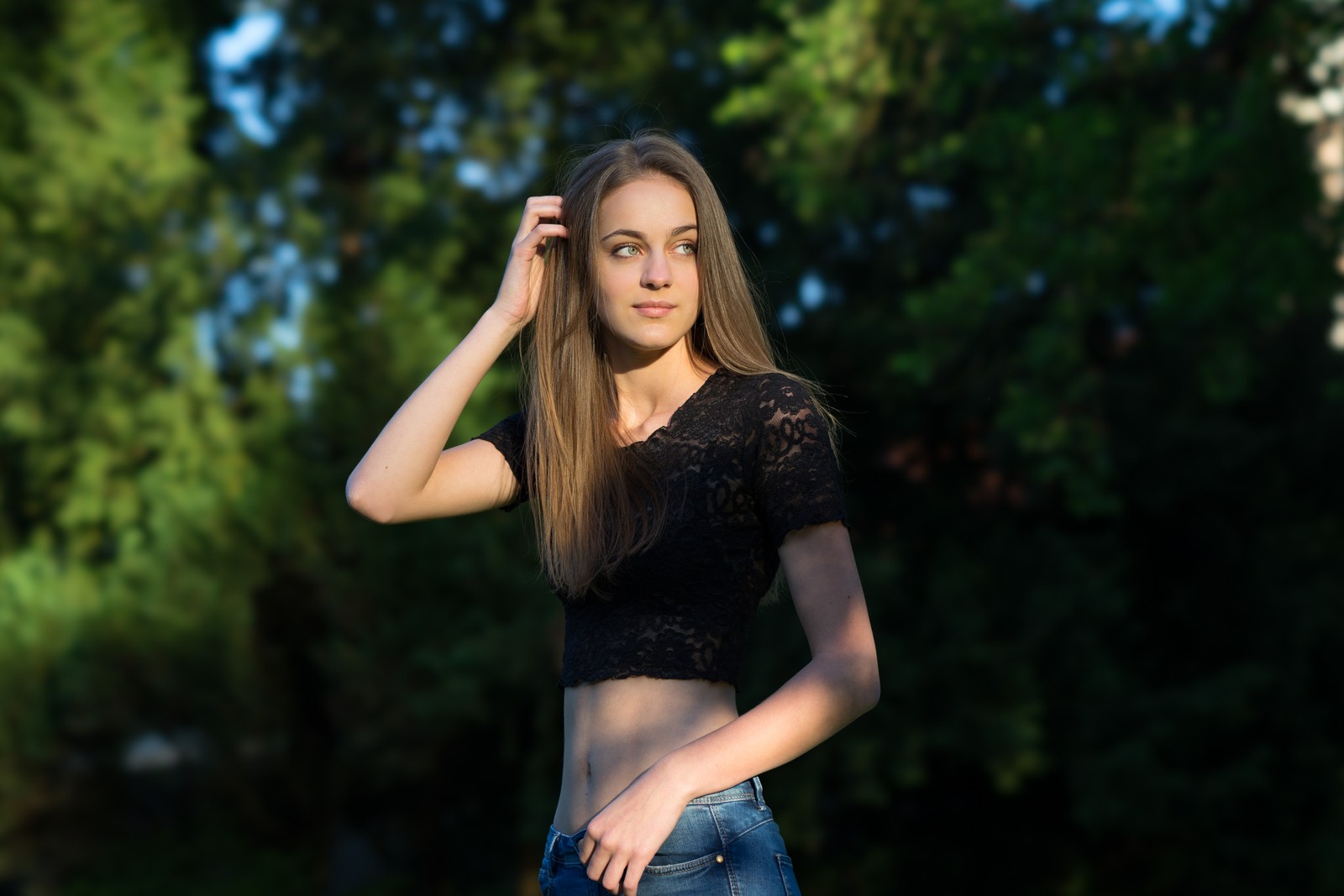 Une femme arabe en haut noir et jeans posant pour une photo (cheveux, nature, beauté, modèle, mode)