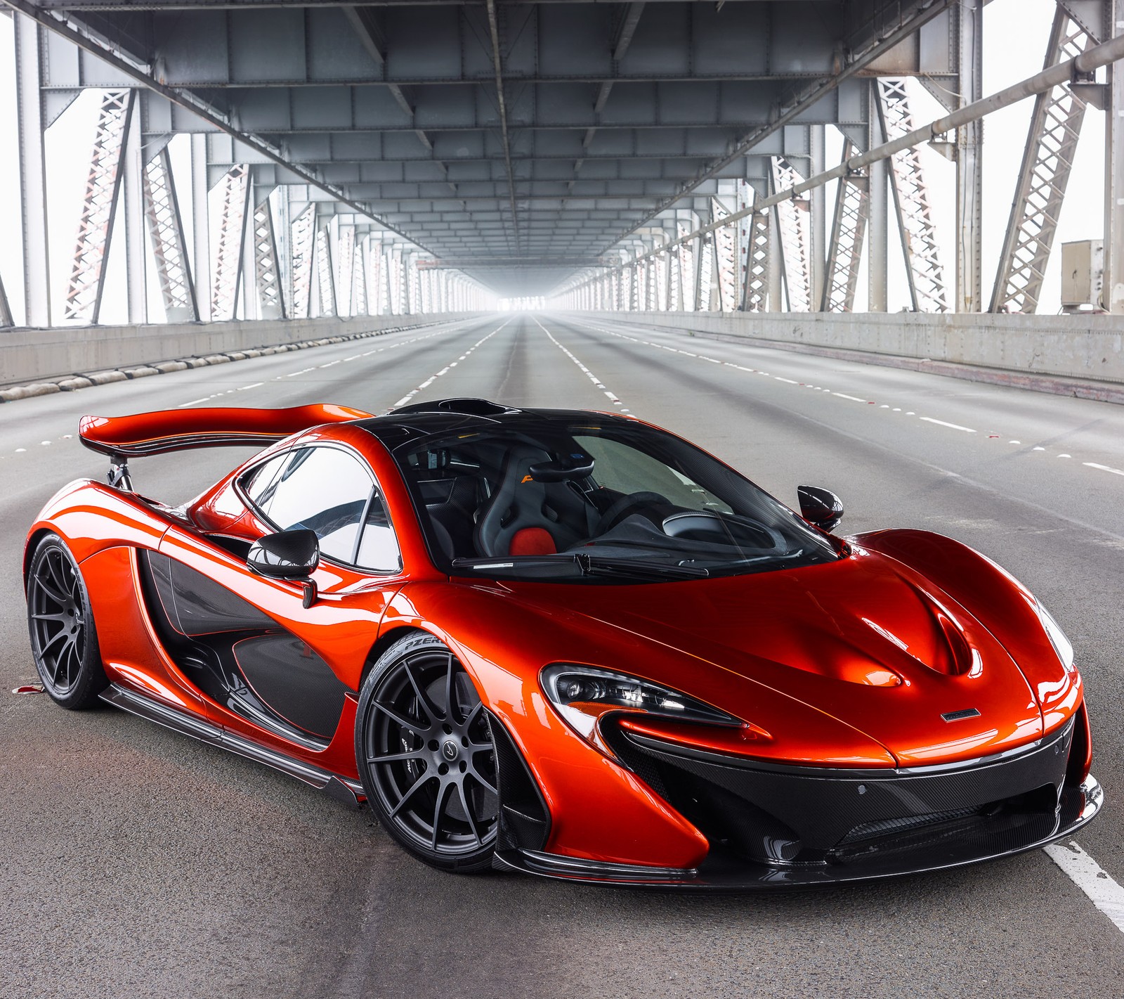 Un coche mclaren rojo conduciendo por una carretera con un puente de fondo (coches, mclaren, p1)