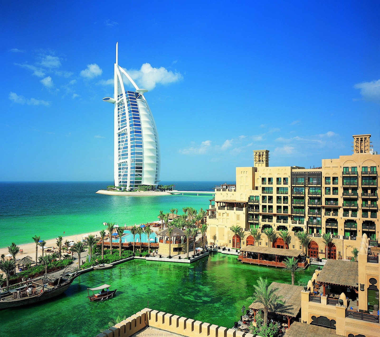 Vista de uma praia com um barco e um hotel (burj, dubai, hotel)