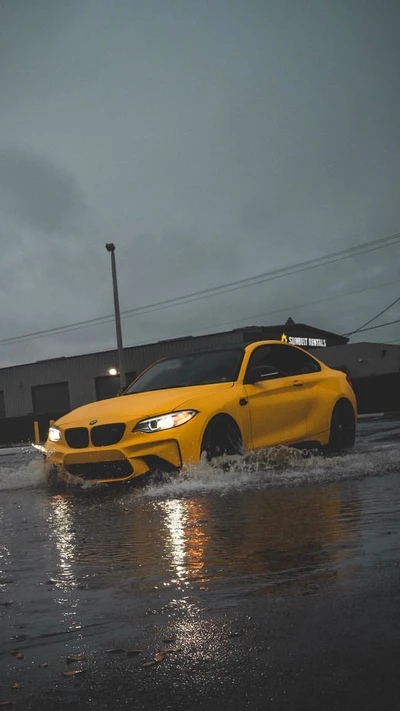 Coupé BMW M2 amarillo en escena urbana lluviosa