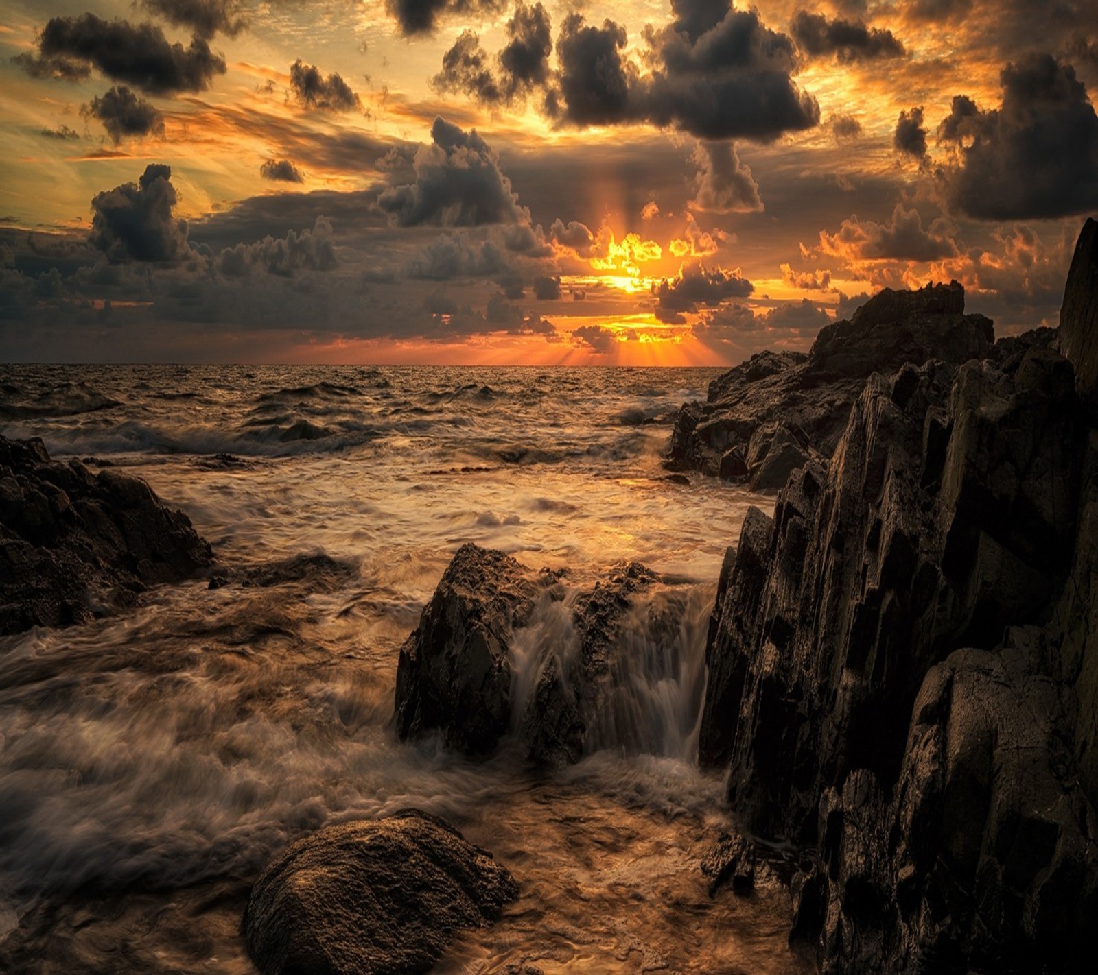 Gros plan d'une plage rocheuse avec un coucher de soleil en arrière-plan (beau paysage, coucher de soleil)