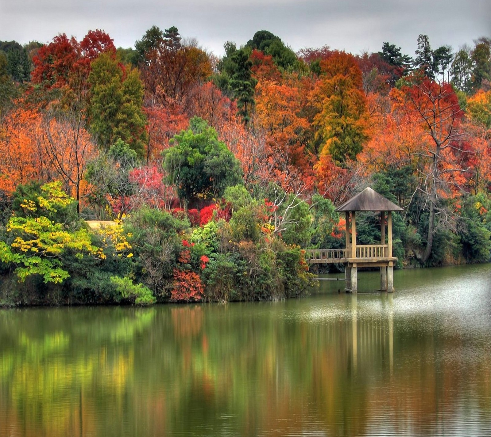 Les arbres changent de couleur en arrière-plan et un pavillon au premier plan (automne, lac, paysage, nature)