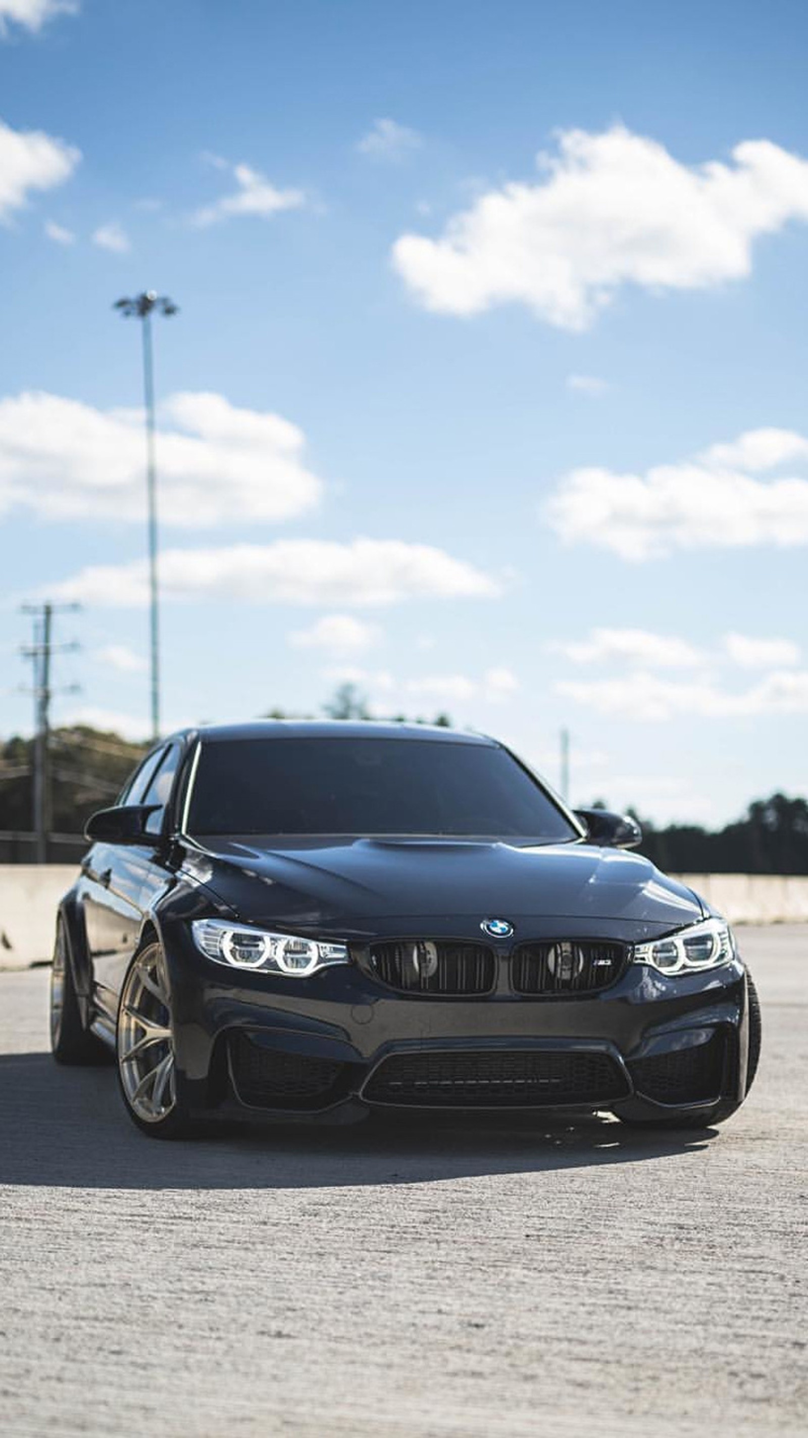 Imagem isométrica de um carro bmw preto estacionado em um estacionamento com um céu ao fundo (bmw, carro, f80, m3, sedã)