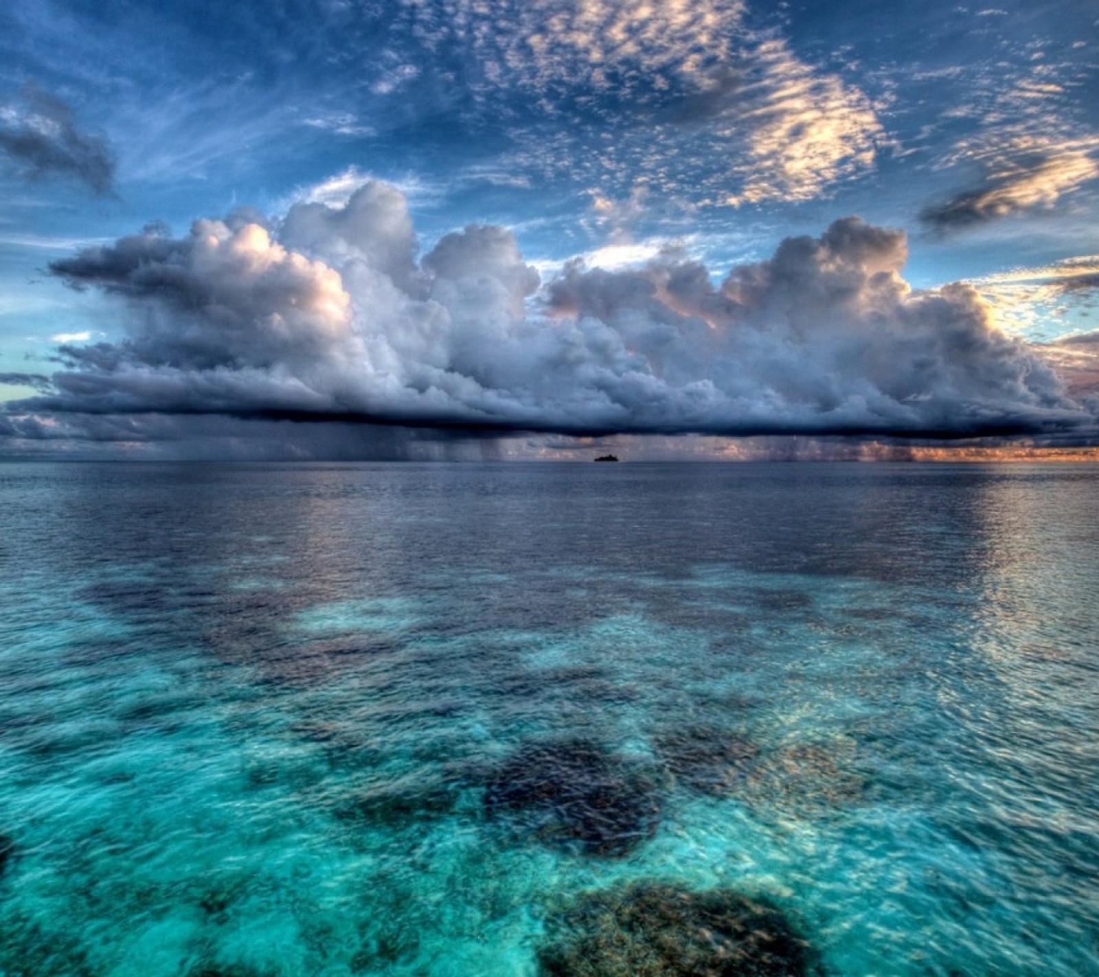 Uma vista de um grande corpo d'água com uma nuvem no céu (azul, mar)