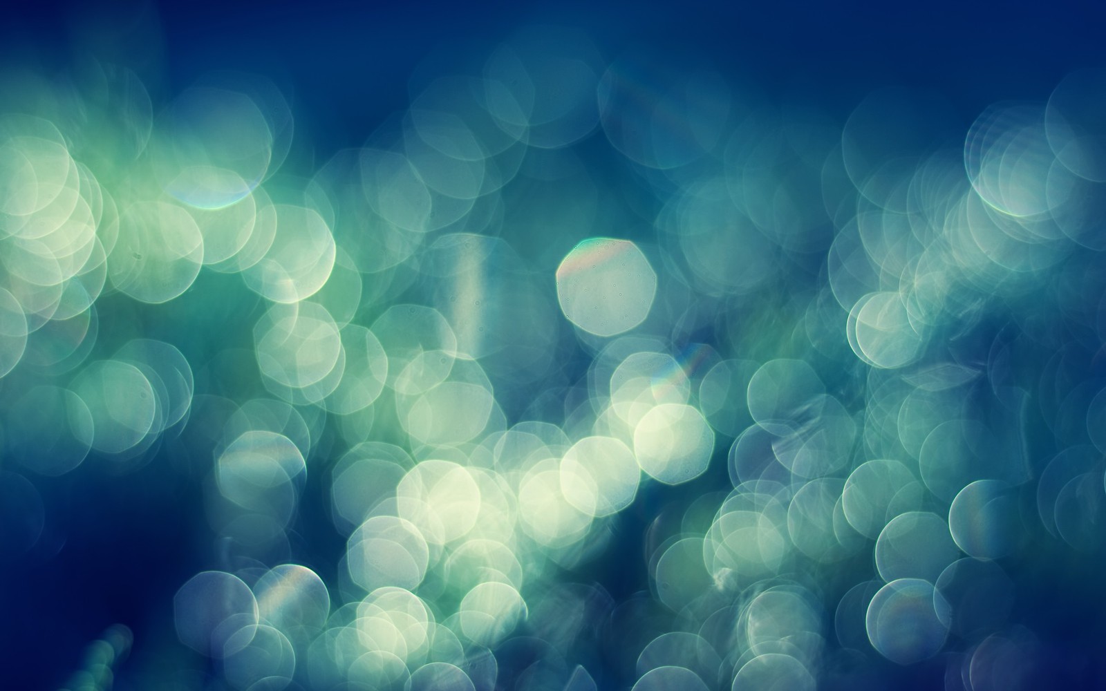 A close up of a blurry photo of a bunch of lights (bokeh, blue, green, turquoise, light)