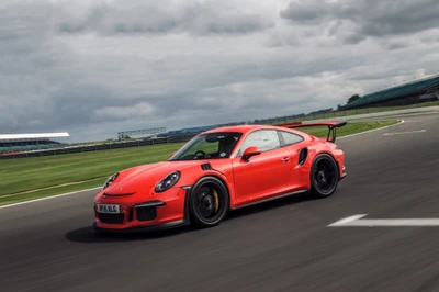 Porsche 911 GT2 em movimento dinâmico em uma pista de corrida, exibindo seu design impressionante e capacidades de desempenho.