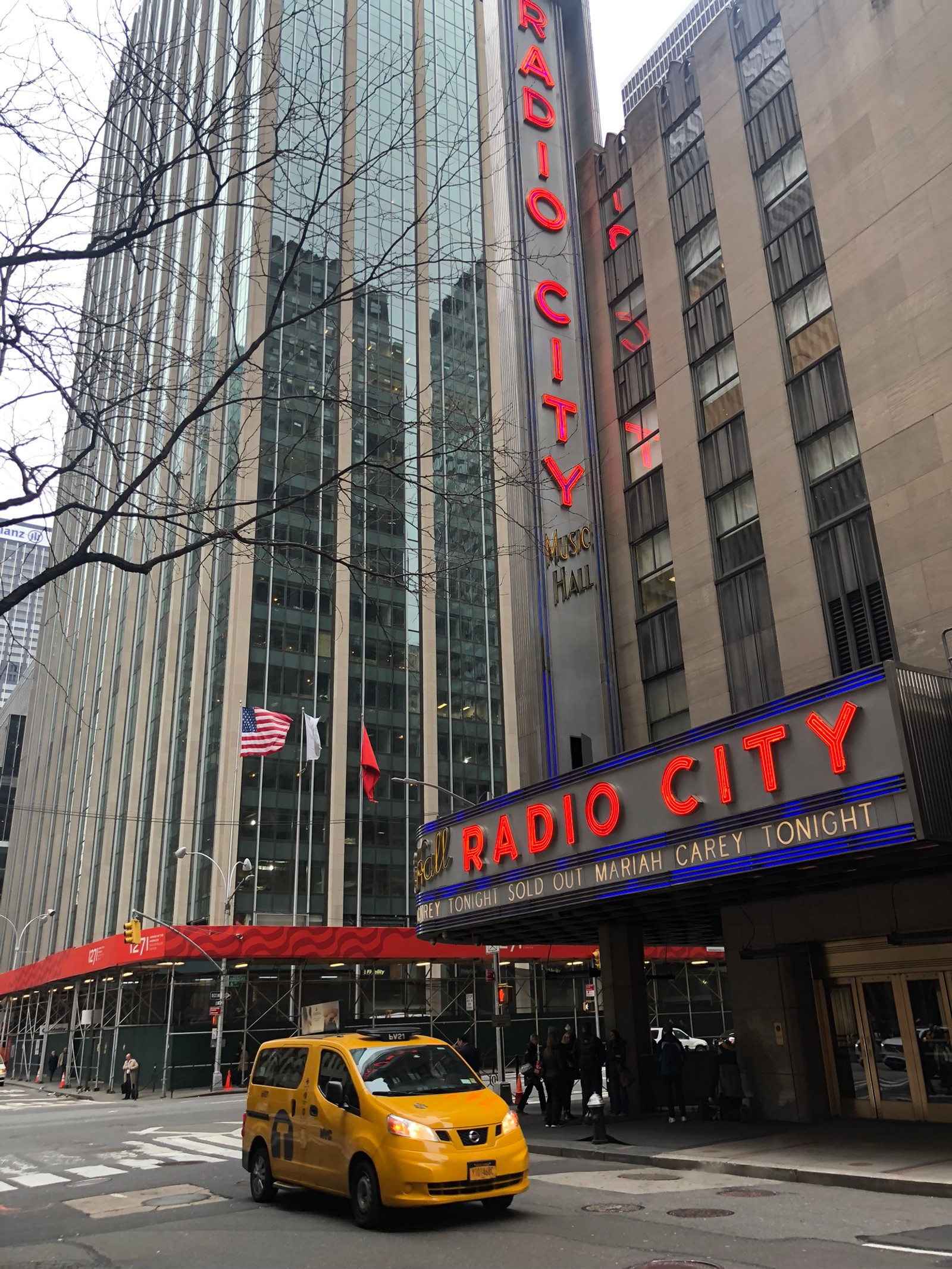 Visão aérea de um táxi amarelo passando pelo radio city theater (nova york, new york city, bloco de torre, metrópole, cidade)