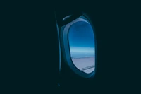 Vista serena desde la ventana del avión: cielos azules y horizontes turquesas