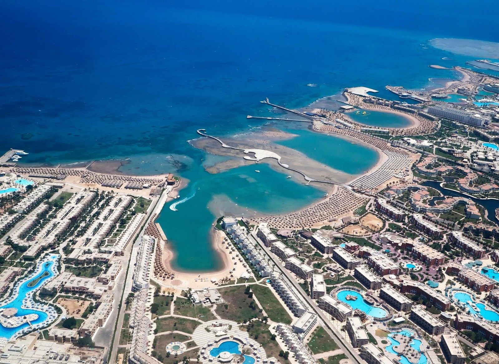 Vista aérea de um resort com uma piscina e uma praia (praia, estância, ilha artificial, formas costeiras e oceânicas, entrada)