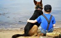 Niño y cachorro disfrutando de un momento sereno junto al agua