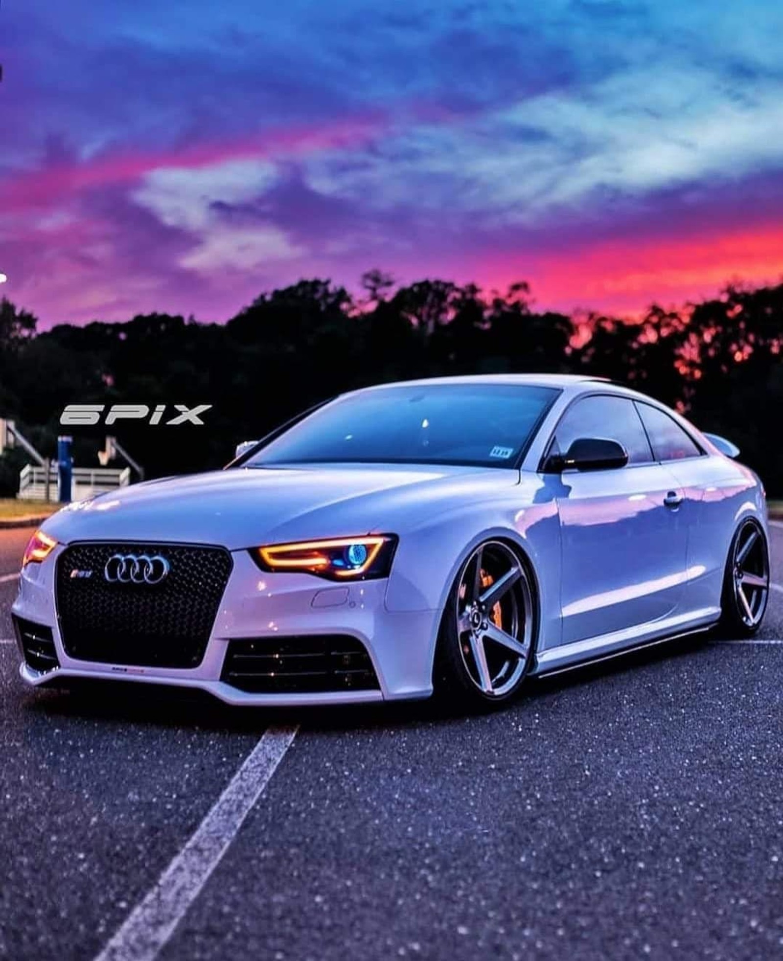 A close up of a car parked on a road near a parking lot (audi, car)