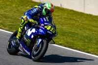 Valentino Rossi en acción en su moto Yamaha MotoGP, mostrando sus legendarias habilidades de carrera.